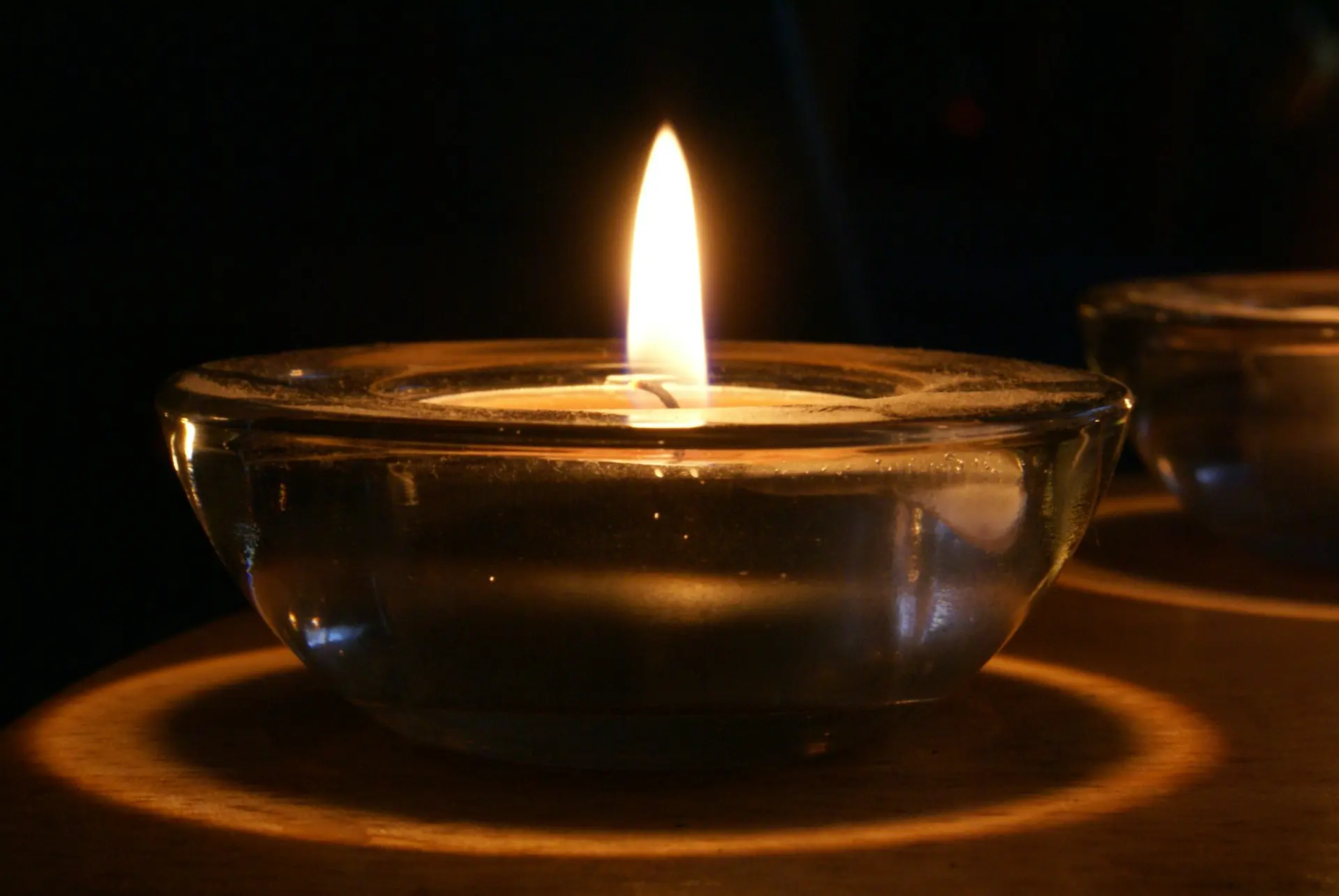 A close up of a lit candle in a bowl